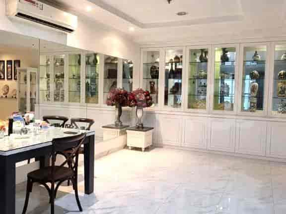 Spacious dining area with a table, chairs, and built-in display cabinets.
