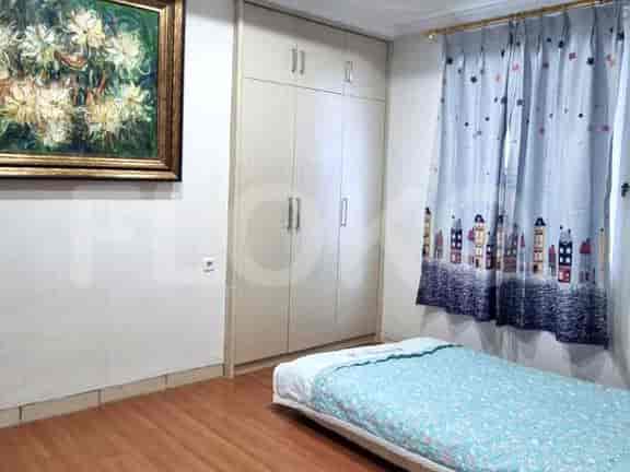 A bedroom with a single bed, a wardrobe, and a painting.