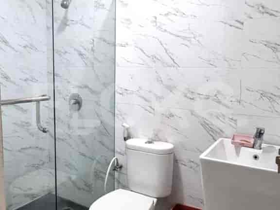 A modern bathroom with a toilet, a sink, and a shower.