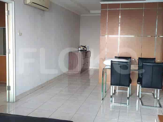 Dining area with glass dining table and black leather chairs.