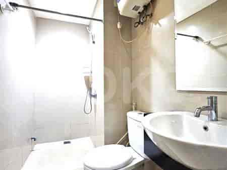 Compact bathroom with a sink, toilet, and shower area.