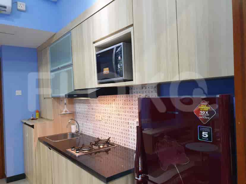Dapur yang lengkap dengan lemari kayu, peralatan, dan meja hitam.