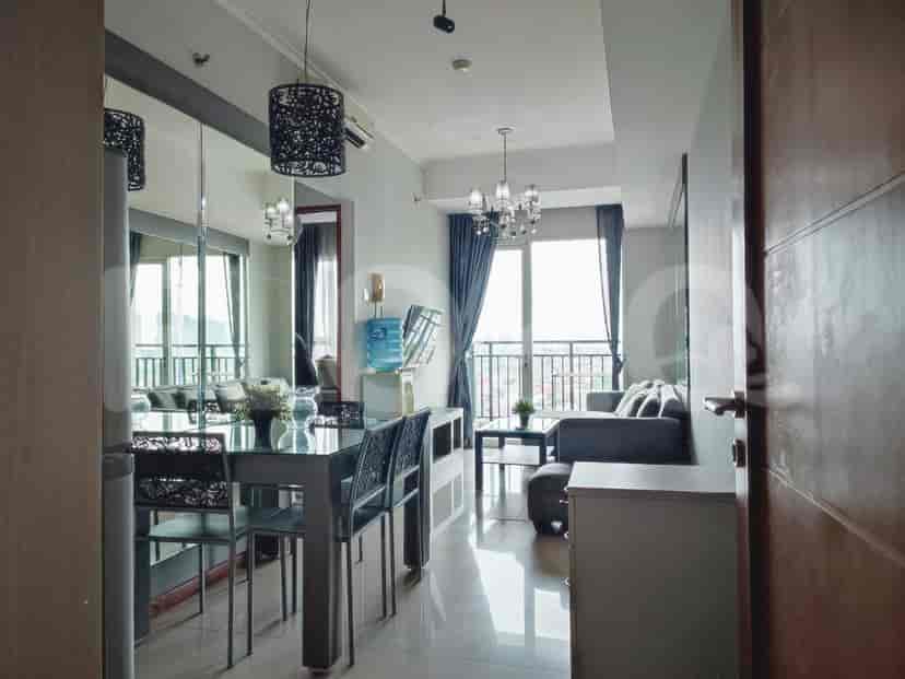 Open-plan living and dining area featuring a dining table, sofa, and city view.