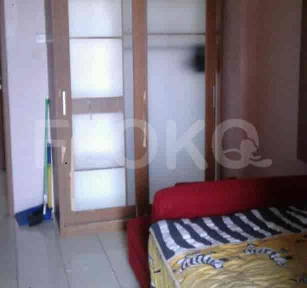 Another view of the bedroom with a red sofa, the bed and a closet.