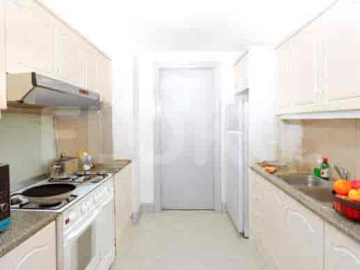 A compact kitchen with white cabinets and essential appliances.