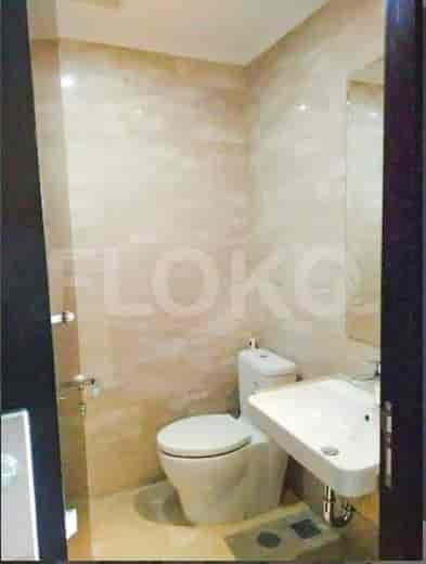 A small bathroom with a white toilet, a sink, and a mirror.