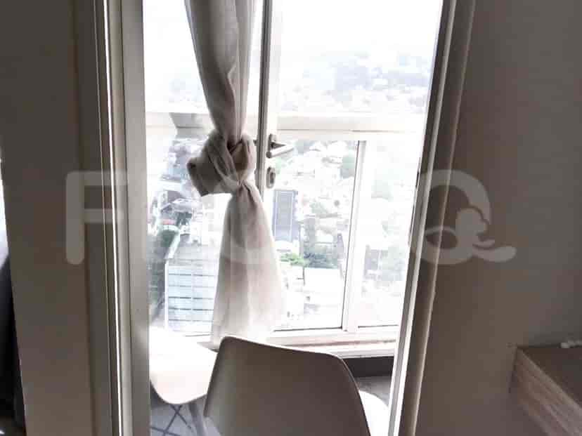 Pemandangan balkon dengan pemandangan kota melalui jendela.
