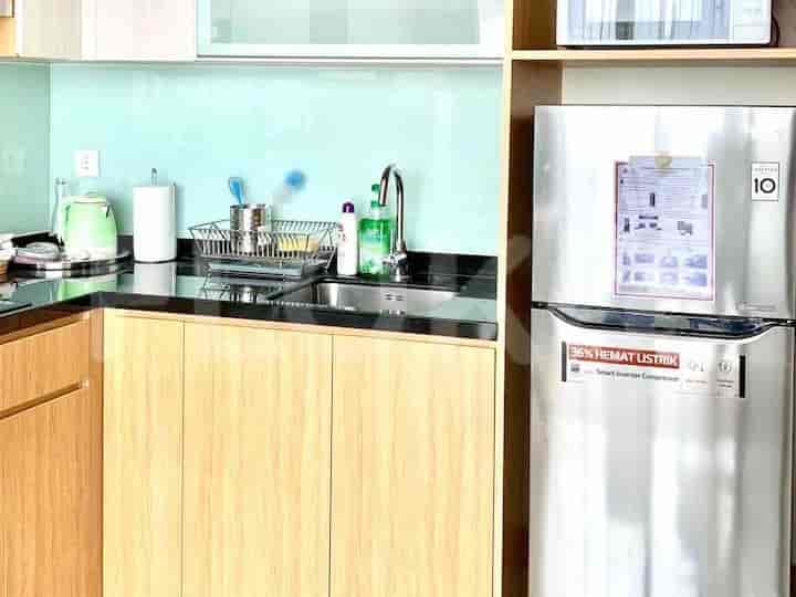 Modern kitchen with stainless steel appliances and light wooden cabinets.