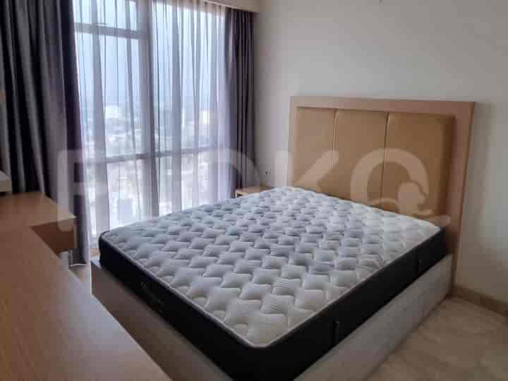 A bedroom with a large bed, a desk, and a view through a window.