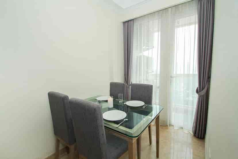 Dining area with a glass table and four chairs.