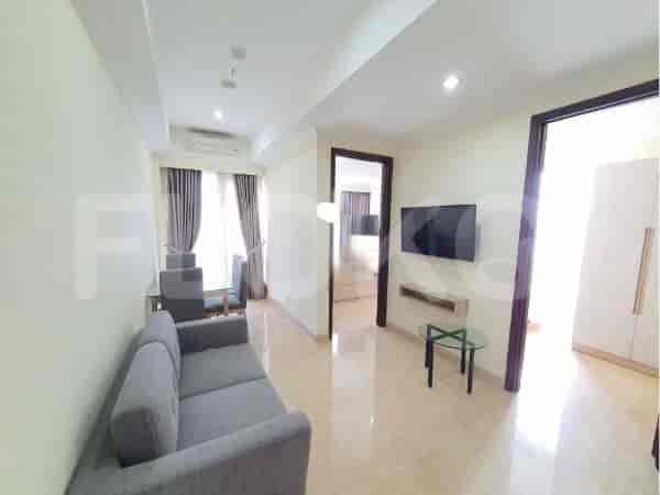 Bright living room with a grey sofa, smart TV, dining area, and access to other rooms.