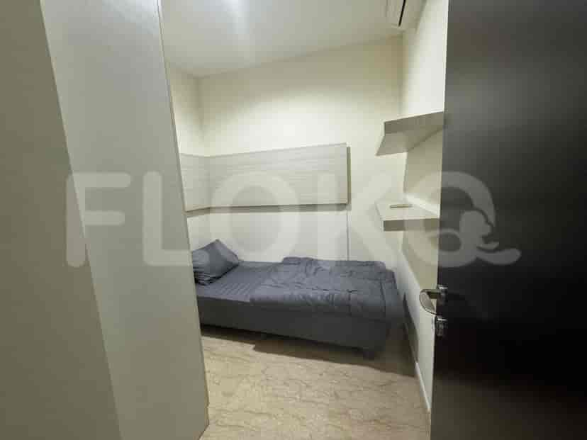 Small bedroom with bed and shelves.