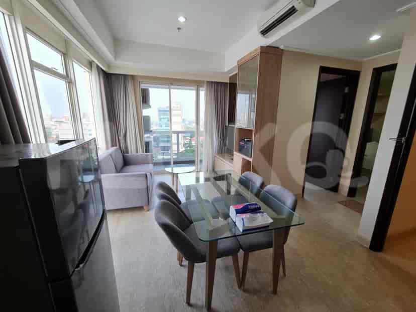 Living room with grey sofa, dining table, and city view.