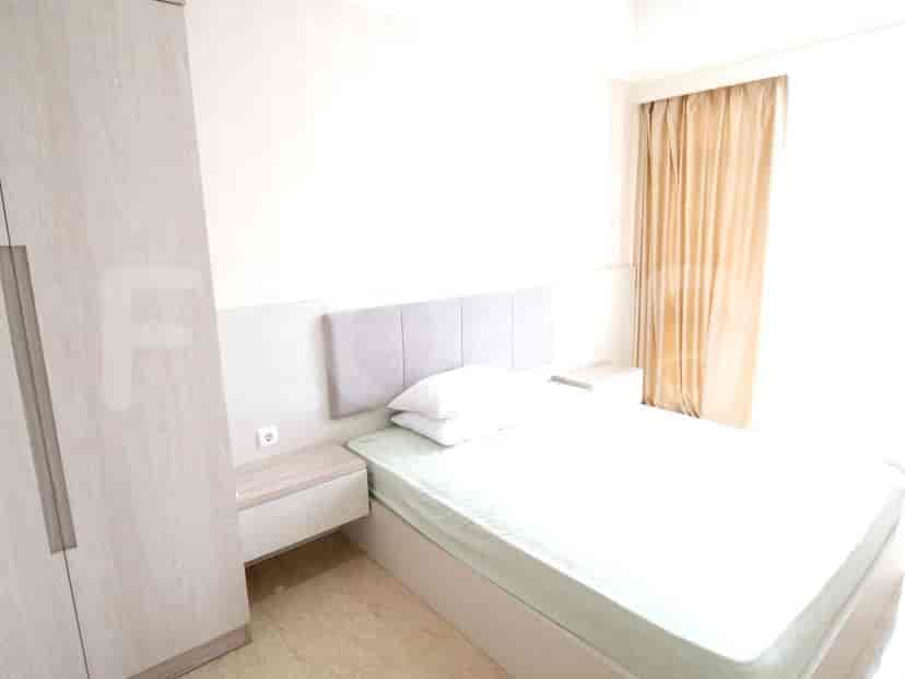 Kamar tidur dengan tempat tidur ganda, meja samping tempat tidur, dan lemari pakaian.