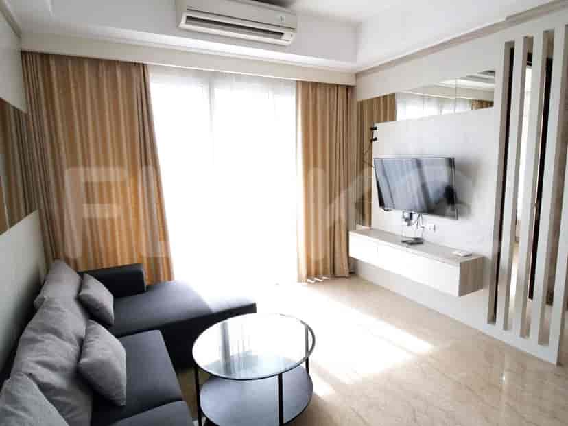 Ruang tamu modern dengan sofa sectional abu-abu, TV, dan berbagai elemen dekoratif.
