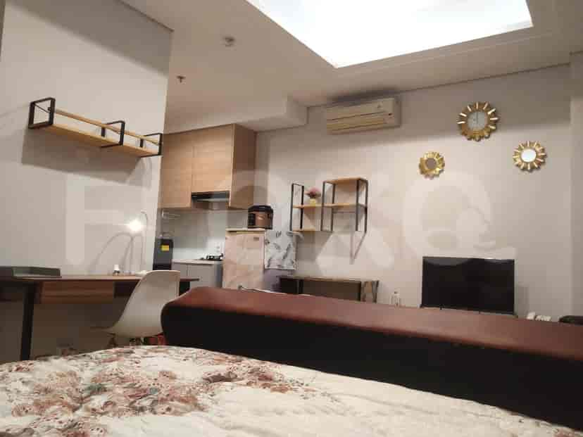 Area gabungan ruang tamu dan dapur yang menampilkan meja, rak, dan desain modern.