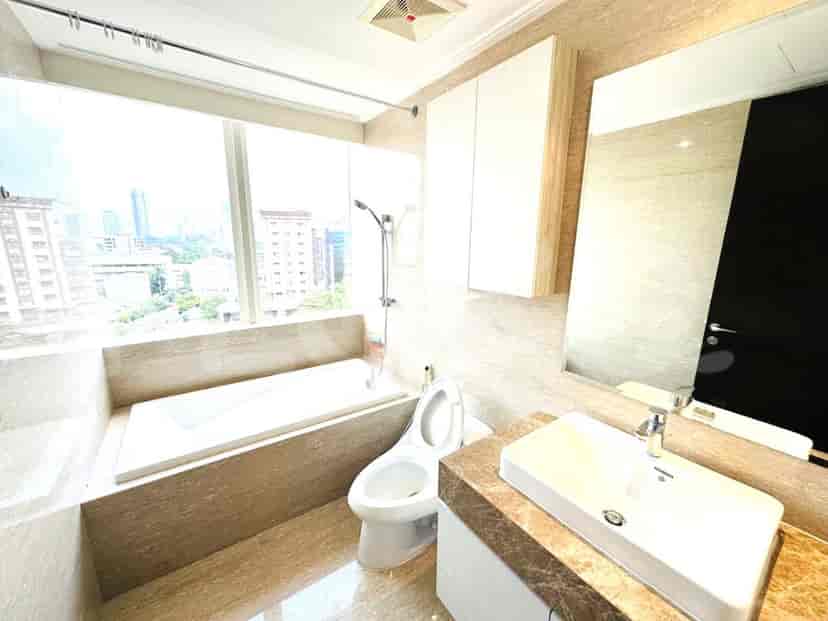 Kamar mandi mewah dengan bak mandi, toilet modern, dan cermin besar.