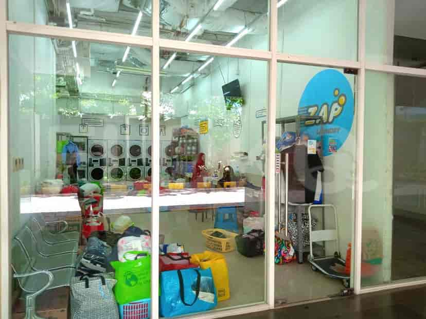A laundry room featuring washing machines and other laundry supplies.