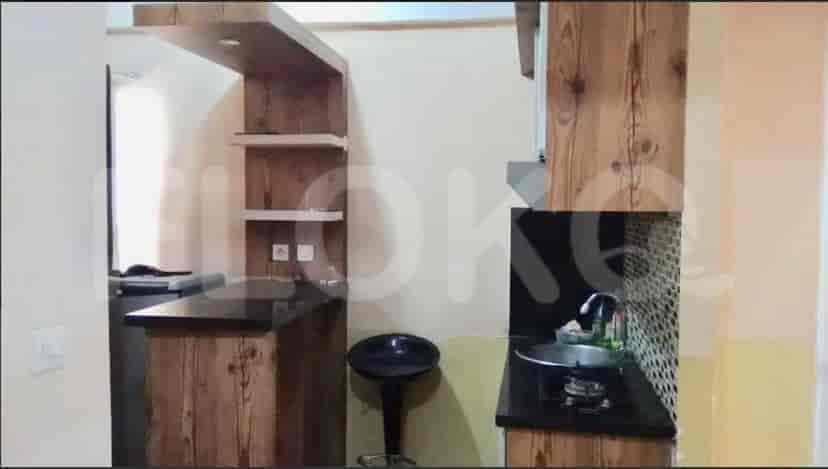 Compact kitchen with wooden cabinets and bar seating.