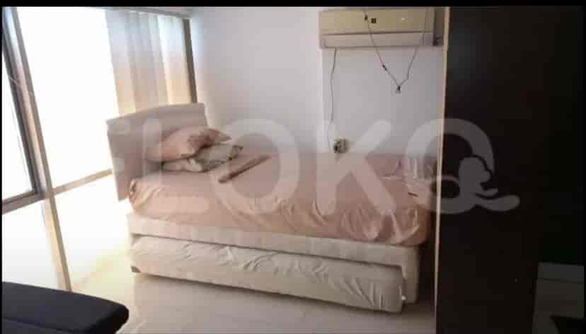 A small bedroom with a single bed, pillows, and an air conditioner.