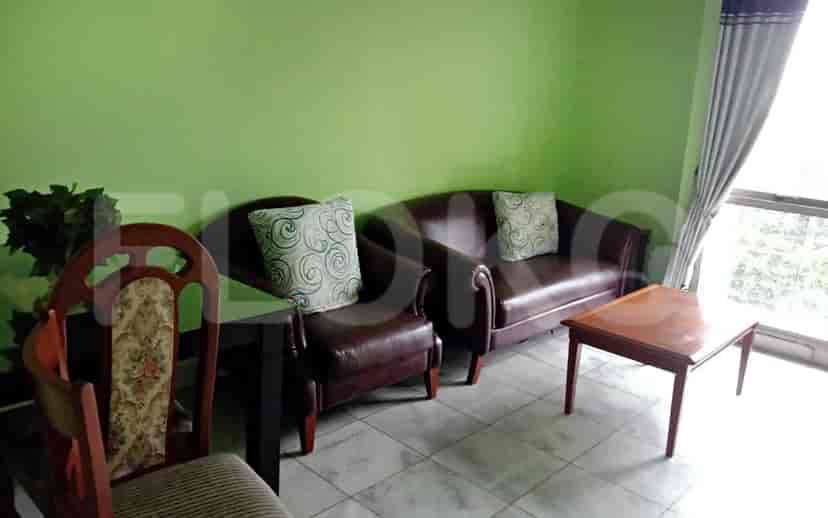 Ruang tamu dengan dua sofa, meja kecil dan kursi.