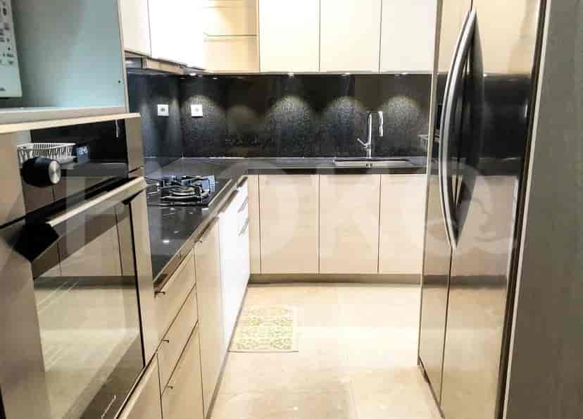 Modern kitchen with stainless steel appliances and black countertops.