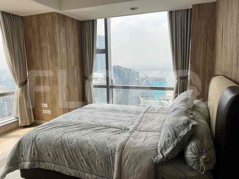 A modern bedroom with a bed, wooden paneling, and a city view.