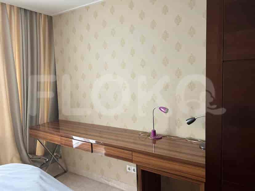 A desk area in a bedroom with a wooden desk, and bedside lamps.