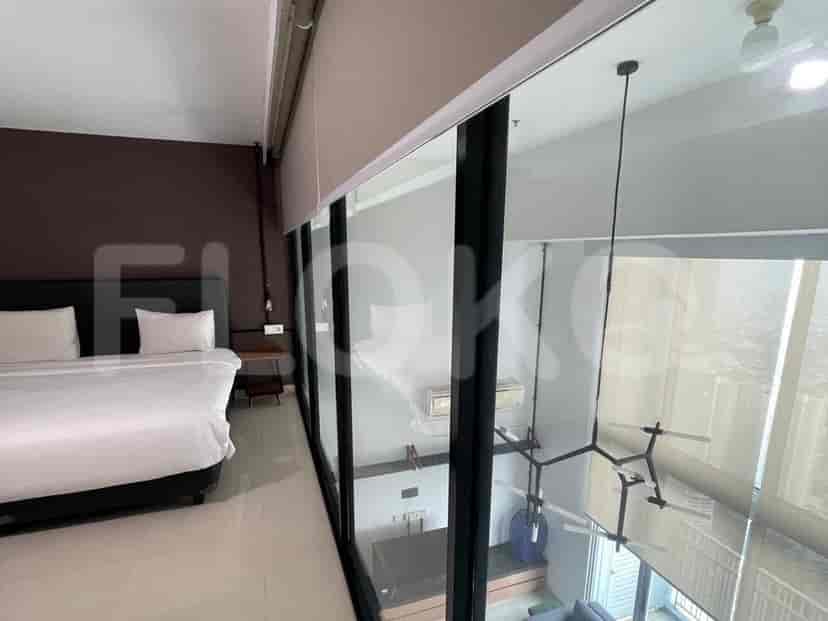 A modern bedroom with a large bed, floor-to-ceiling windows, and a neutral color palette.