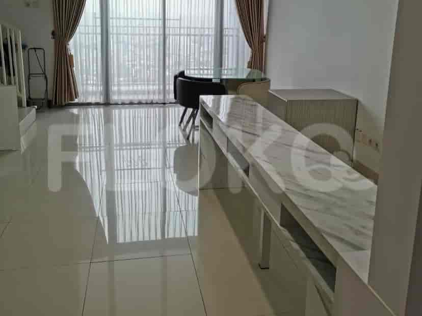 Dining area with glass table and marble counter, providing a bright and open feel.