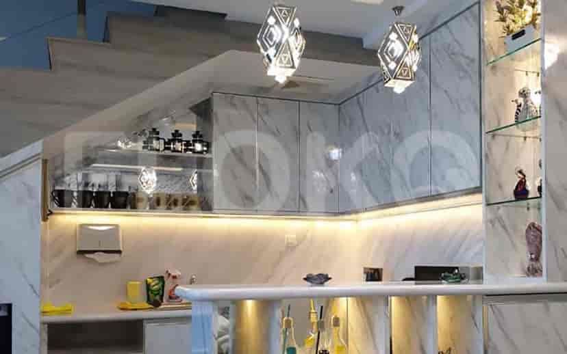 Another view of the kitchen with marble finishes and modern lighting.