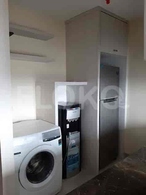 Kitchen with a washing machine, fridge, and water dispenser.