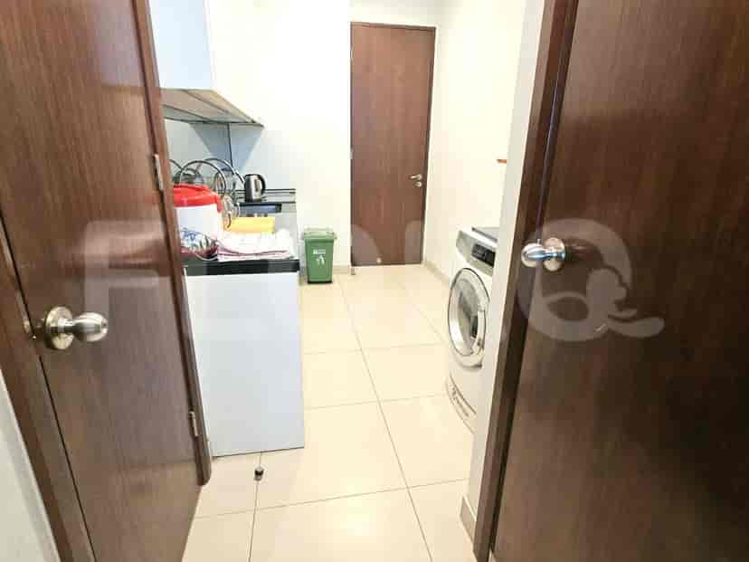 A small laundry room with a washing machine and other storage items.