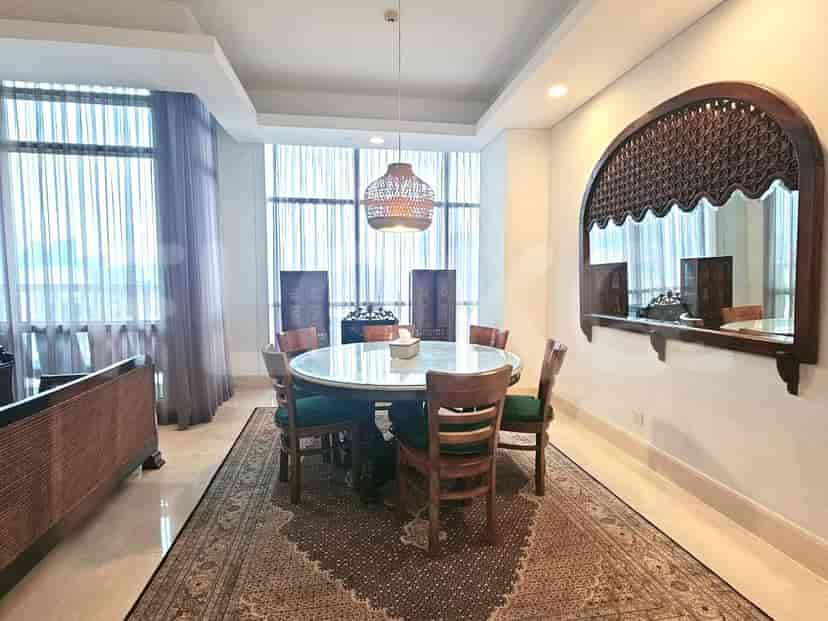 A dining area with a round table, chairs, and decorative wooden elements.