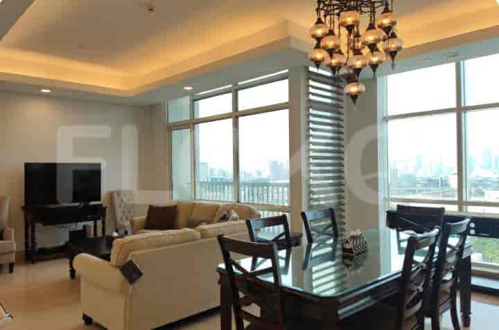 A luxurious living and dining area featuring a cream-colored sofa, wooden dining table, and city views.