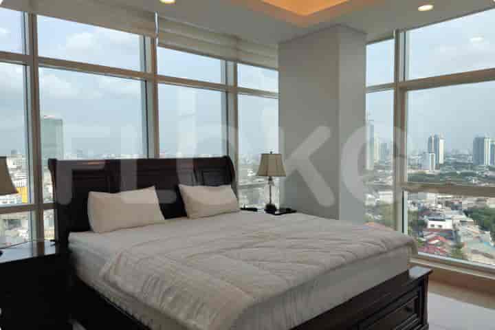 A spacious master bedroom with a king-sized bed, large windows, and city views.