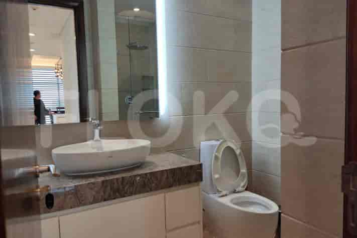 A modern bathroom with a white sink, toilet, and large mirror.