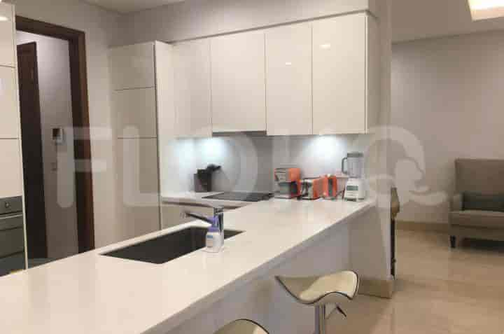 A modern kitchen with white cabinets, a breakfast bar, and stainless steel appliances.