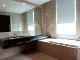 Kamar mandi modern dengan bak mandi, shower, dan wastafel.