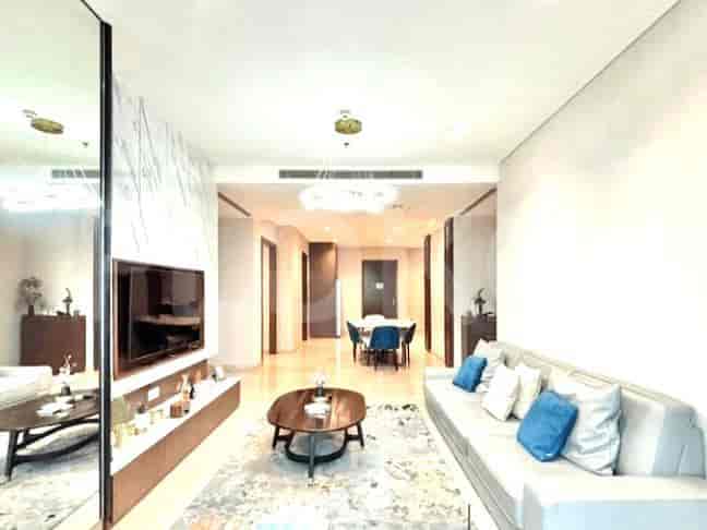 Modern living room with a large TV, a sleek sofa, and a mirrored wall.