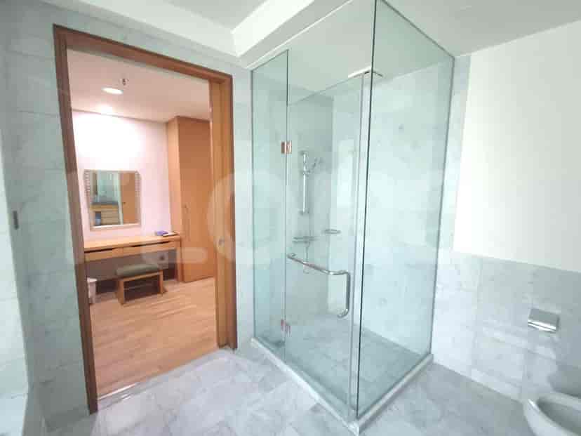 Bathroom with a glass shower, and view into the dressing room.