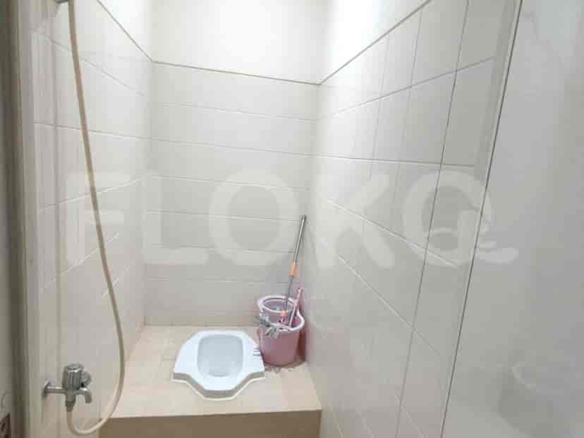A small toilet room with a squat toilet.