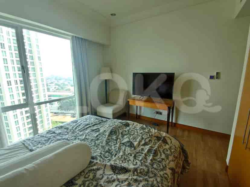Bedroom with a bed, TV, and large windows with a city view.