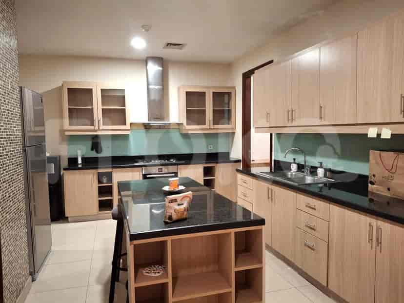A modern kitchen with light wood cabinets, a black countertop, and a kitchen island.