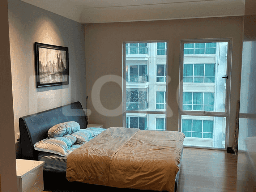 A stylish bedroom featuring a bed, a picture on the wall, and natural light.
