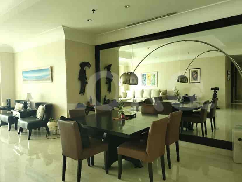 A dining area with a large mirror and a dining table.