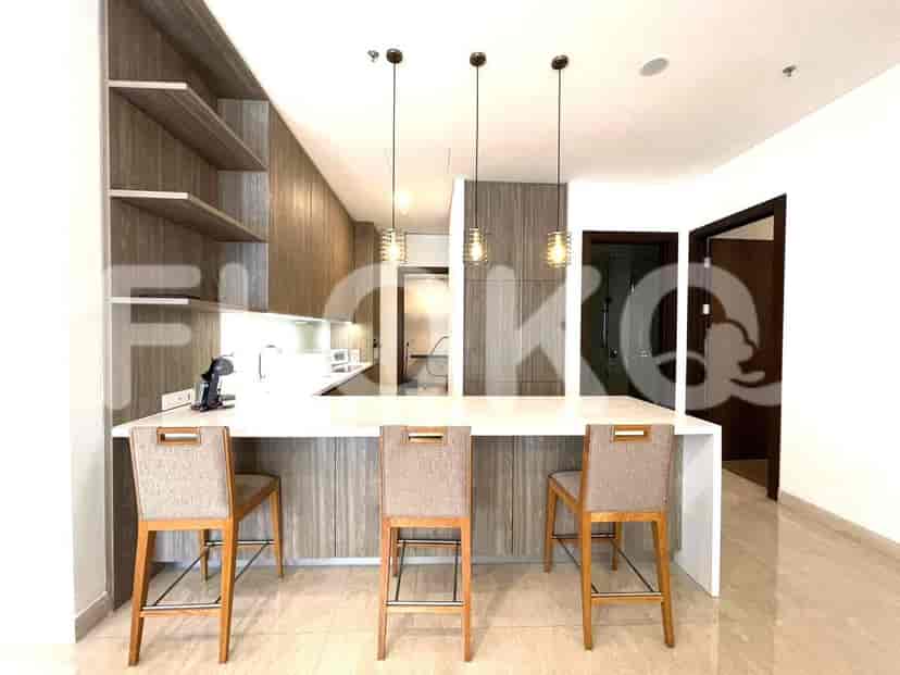 A modern, open-concept kitchen featuring wooden cabinetry, a breakfast bar, and modern appliances.