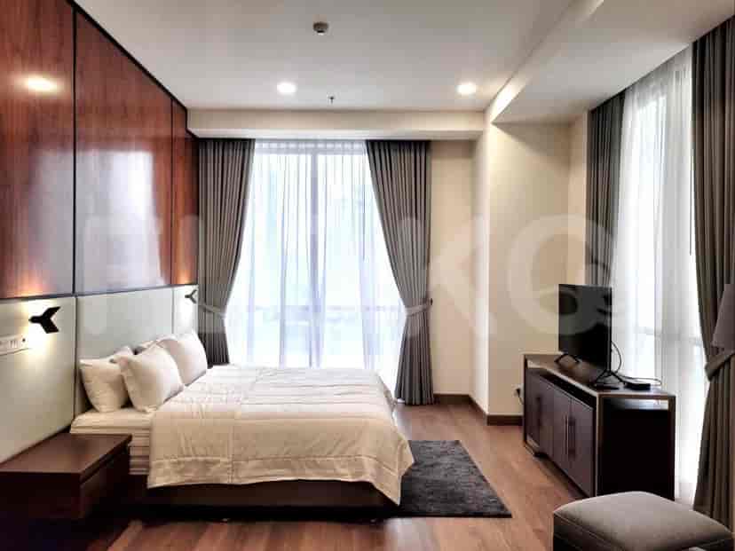 Kamar tidur modern dengan tempat tidur, TV, dan jendela besar.