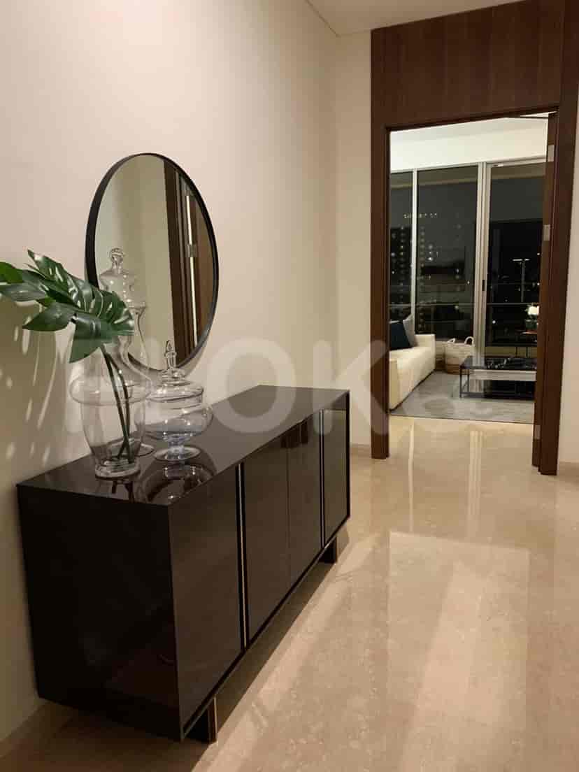 A hallway with a cabinet and a mirror.