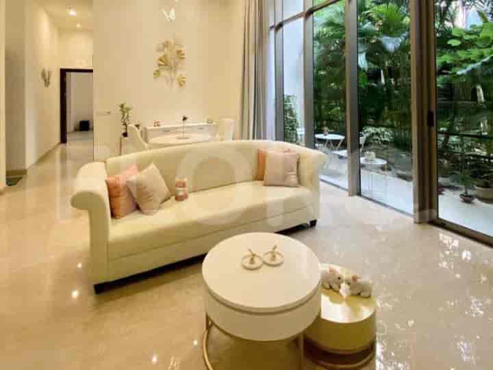 A cream-colored sofa with pink pillows and a round coffee table.
